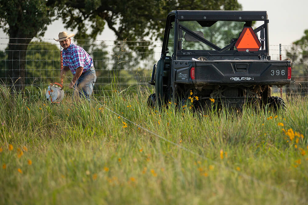 Rancher setting up temporary wire fencing.